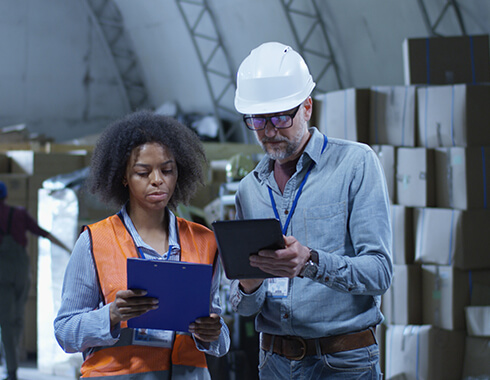 man and woman in warehouse with clipboards