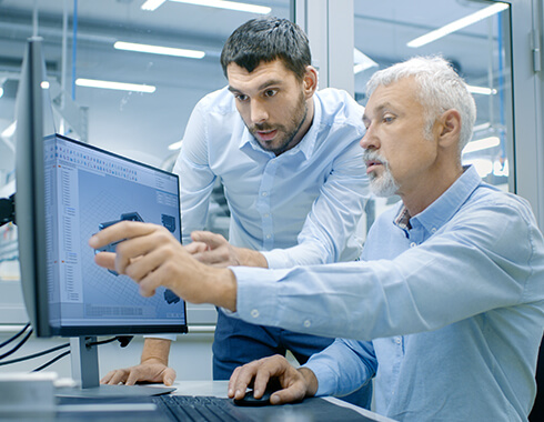 2 men around laptop reveiwing data